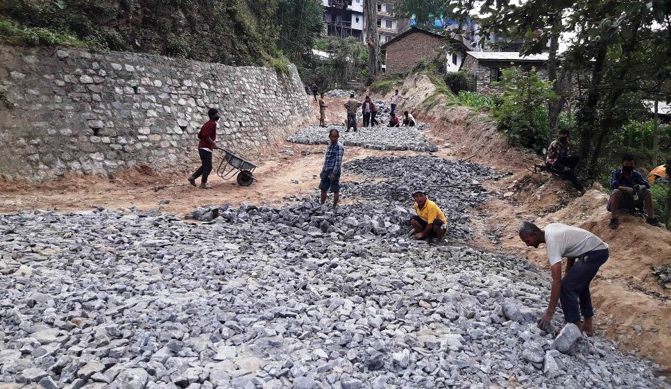 दिक्तेल–खानीडाँडा सडक अन्तरगत दिक्तेलबजारमा आरसिसि ढलानका लागि  ग्राभेल गर्दै कामदार ।